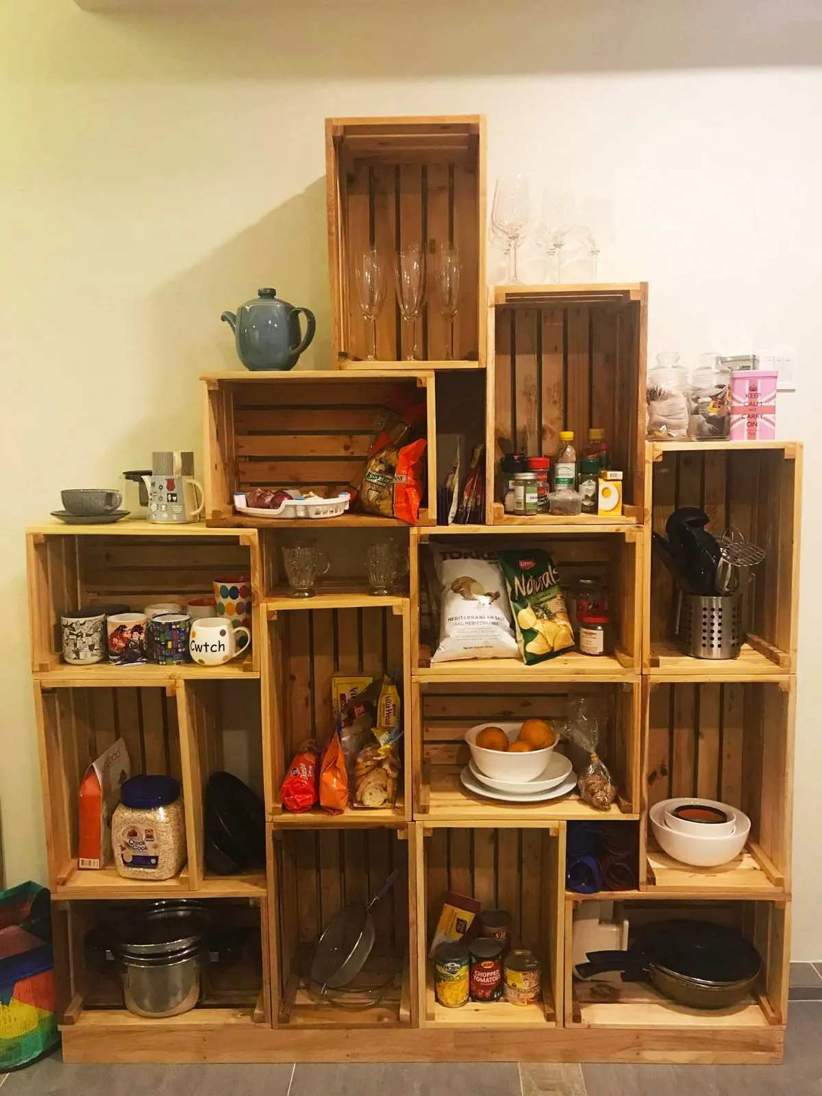 Shelving made from reclaimed wooden crates, filled with kitchenware