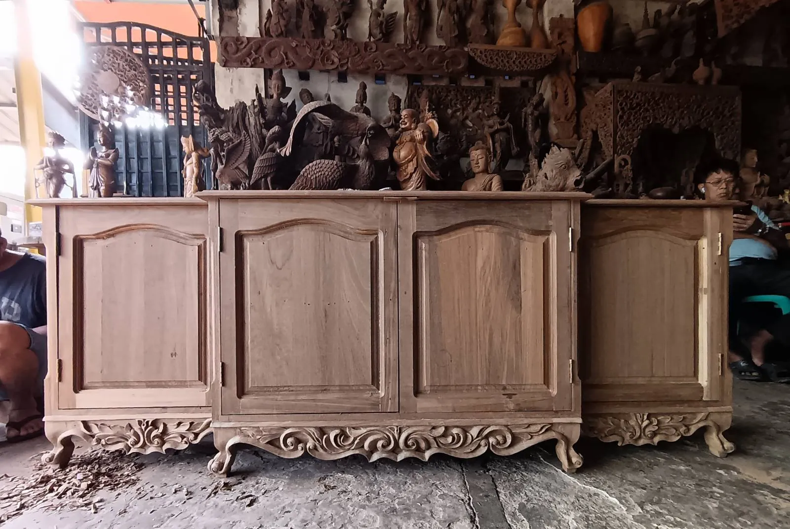 A hand-carved sideboard surrounded by carvings in the Mickey's workshop